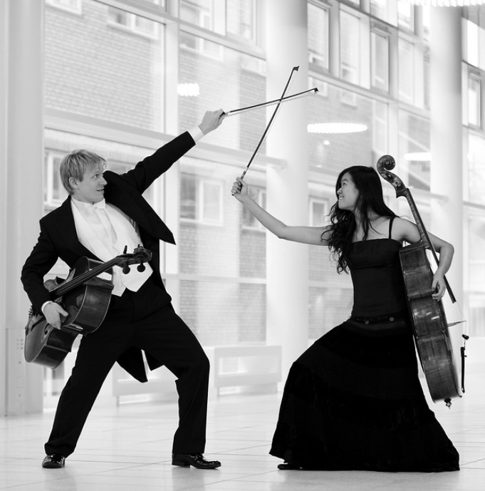 Duo de violoncellistes croisant leurs archets